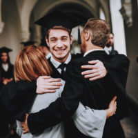 College graduate hugs his parents