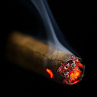 burning cigar on black background