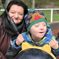 mother plays with down syndrome sound in playground