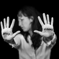 woman that has stop violence written on hands