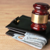 gavel on top of money with wallet for garnishment concept