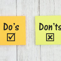 Do's and Don'ts on two sticky notes  on weathered whitewash textured wood