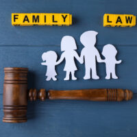 Flat lay composition with figure and gavel on blue wooden background. Family law concept
