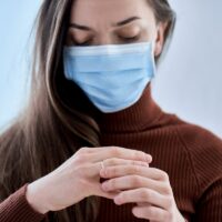 Woman in protective mask remove ring from finger. Break up relationship and divorce after living together during quarantine and isolation due to coronavirus covid epidemic. Divorce concept
