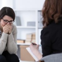 Sad woman crying during psychotherapy at professional clinic