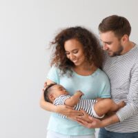 Portrait of happy interracial family on light background