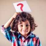 Kid boy with question mark. Children, education and emotions concept