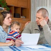 Worried family with child sitting at home