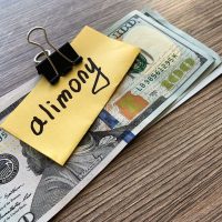 Payments alimony. Pile Dollars with sign alimony and money. Divorce and separation concept