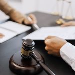 Lawyer preparing to sign a contract and wooden gavel on table justice and law concept.