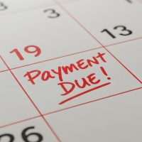 Close Up of a Calendar with Red Payment Due Reminder on White Background Close Up of a Calendar with Red Payment Due Reminder on White Background