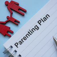 Parenting plan on the table. Symbolizing co-parenting strategies. Parenting plan on the table. Symbolizing co-parenting strategies.
