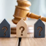 Judge gavel and house icons with question marks on table, property division after divorce, marital assets dispute, family law settlement, real estate ownership legal resolution concept