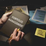 a-person-holds-a-notebook-titled-portfolio-management